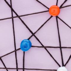 אילוסטרציה: סיכות צבעוניות מחוברות באמצעות רשת של חוטים