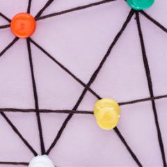 אילוסטרציה: סיכות צבעוניות מחוברות באמצעות רשת חוטים