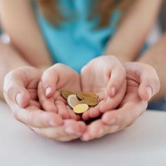 אילוסטצרציה: הורה וילדה אוחזים מטבעות
