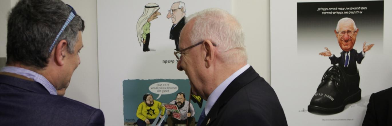 נשיא המדינה ראובן ריבלין על רקע קריקטורה שלו