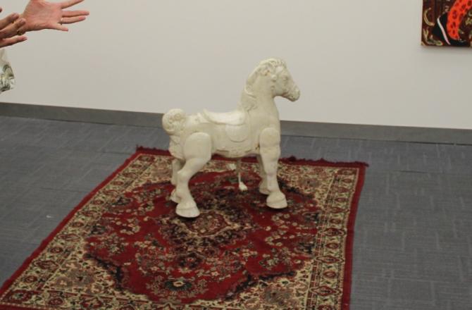 סוס עץ לבן על שטיח בתערוכה
